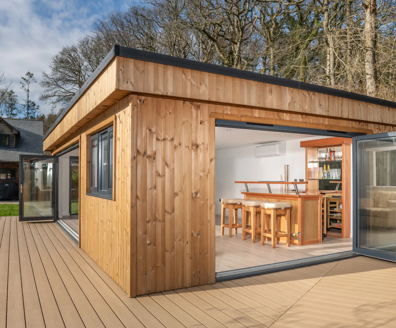 Exterior of modern garden room with bar area visible through large windows